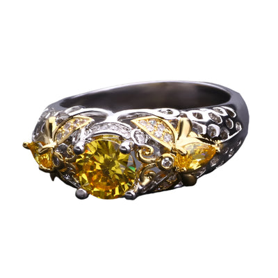 Decorative ring with yellow gemstone and gold accents on a dark background