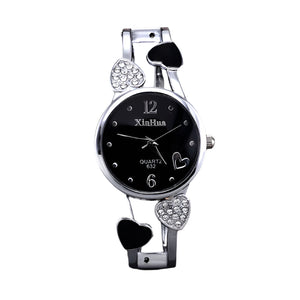 Silver wristwatch with heart designs on a black background