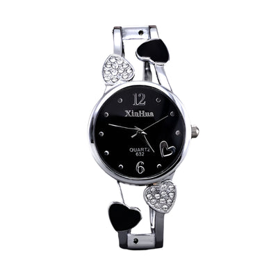 Silver wristwatch with heart designs on a black background